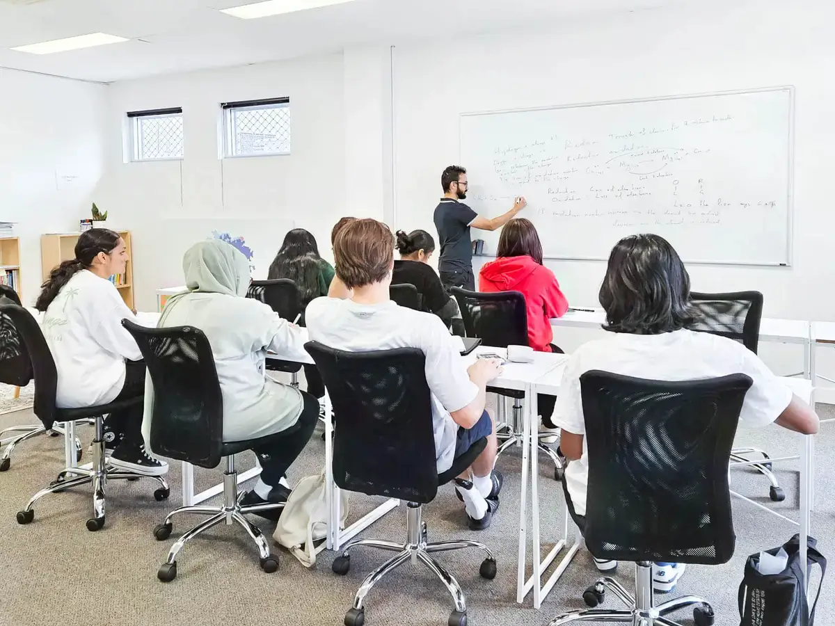 Tutor teaching at the whiteboard during an Academis class